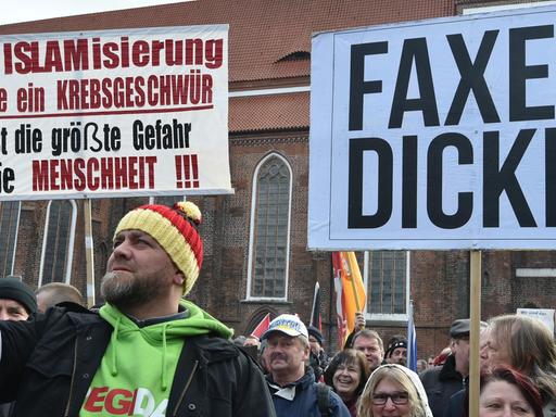 Cottbus: Ein Demonstrant filmt mit dem Handy die Plakate auf dem Oberkirchplatz. Der Verein Zukunft Heimat e.V. hatte zu der Demonstration aufgerufen.