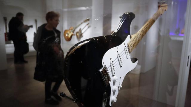 Hinter der Stratocaster Gitarre von Eric Clapton sind sich ein paar Ausstellungsbesucher im Metropolitan Museum of Art
