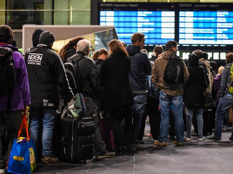 Fahrgäste stehen am 05.10.2017 auf dem Hauptbahnhof in Berlin in einer Warteschlange an einem Informationsschalter der Deutschen Bahn an.