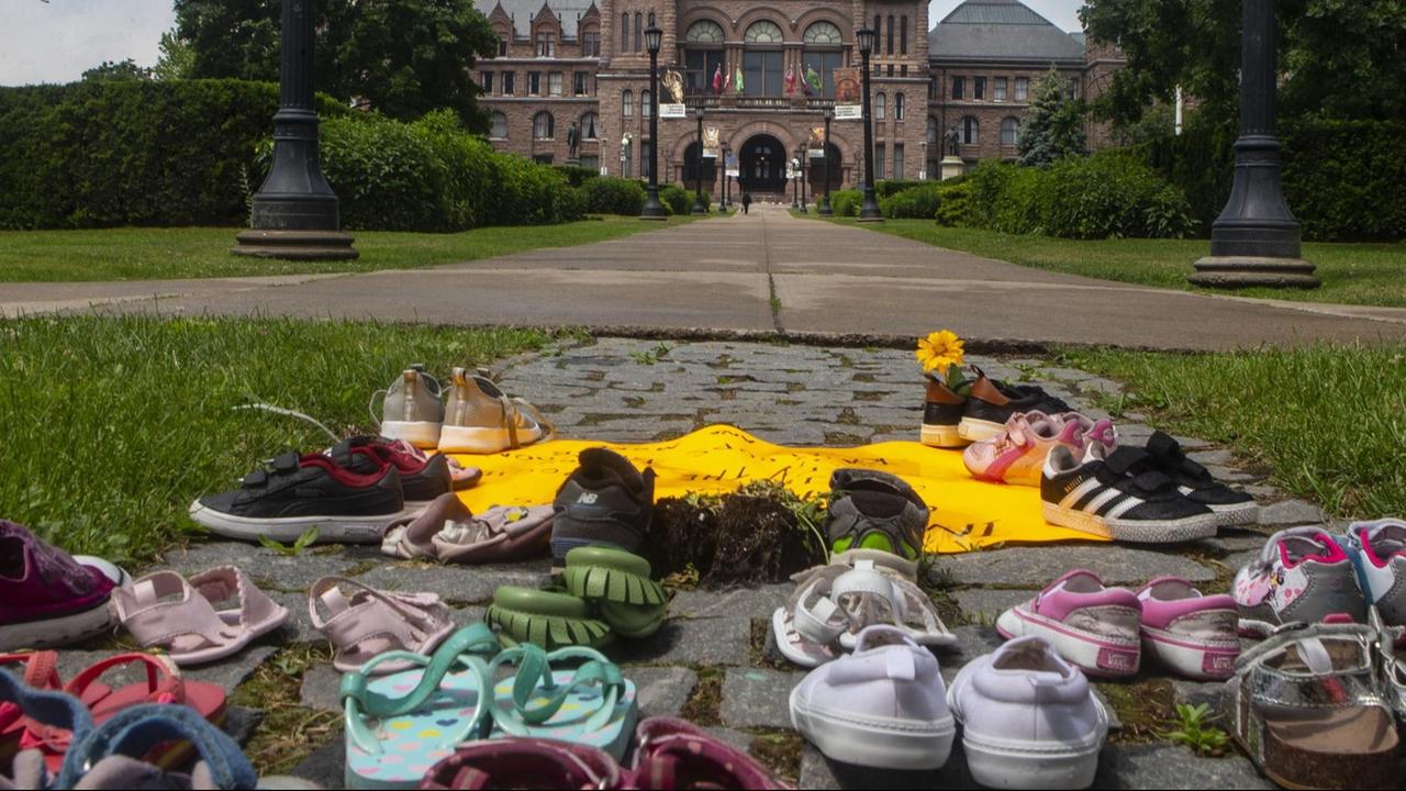 Kinderschuhe liegen auf dem Boden in Sichtweite des Regierungsgebäudes im kanadischen Bundesstaat Ontario. Sie sollen an die toten indigenen Kinder erinnern, deren Gräber auf dem Gelände einer ehemalgen "Residential School" entdeckt wurden. Kinderschuhe liegen auf dem Boden in Sichtweite des Regierungsgebäudes im kanadischen Bundesstaat Ontario. Sie sollen an die toten indigenen Kinder erinnern, deren Gräber auf dem Gelände einer ehemalgen "Residential School" entdeckt wurden.