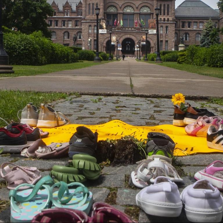 Kinderschuhe liegen auf dem Boden in Sichtweite des Regierungsgebäudes im kanadischen Bundesstaat Ontario. Sie sollen an die toten indigenen Kinder erinnern, deren Gräber auf dem Gelände einer ehemalgen "Residential School" entdeckt wurden.