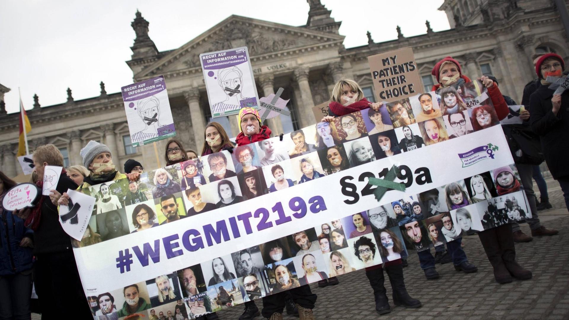 Frauen mit Plakat "wegmit219a" und zugeklebten Mund auf einer Kundgebung von verschiedenen Frauenorganisationen und Abgeordnete zur Gesetzesinitiative vom Deutschen Bundestag zur Streichung oder Änderung und gegen das Informationsverbot fÜr Schwangerschaftsabbruch unter dem Motto "Weg mit dem Paragraph 219a StGb" vor dem Reichstag in Berlin. Frauen mit Plakat "wegmit219a" und zugeklebten Mund auf einer Kundgebung von verschiedenen Frauenorganisationen und Abgeordnete zur Gesetzesinitiative vom Deutschen Bundestag zur Streichung oder Änderung und gegen das Informationsverbot fÜr Schwangerschaftsabbruch unter dem Motto "Weg mit dem Paragraph 219a StGb" vor dem Reichstag in Berlin.