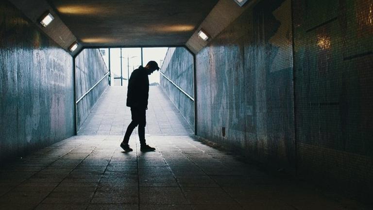 Ein Mann steht am Ende eines dunklen Tunnels. Ein Mann steht am Ende eines dunklen Tunnels.
