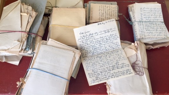 Handschriftliche Briefe, gestapelt, auf einer roten Holzkiste Handschriftliche Briefe, gestapelt, auf einer roten Holzkiste