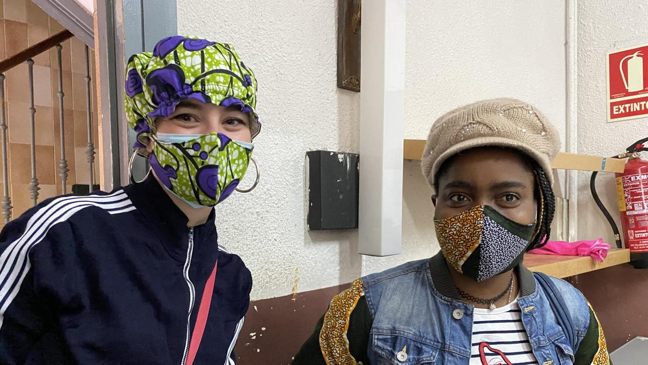 Zwei junge Mädchen mit buntem Mundschutz und Kopfbedeckung. Zwei junge Mädchen mit buntem Mundschutz und Kopfbedeckung.