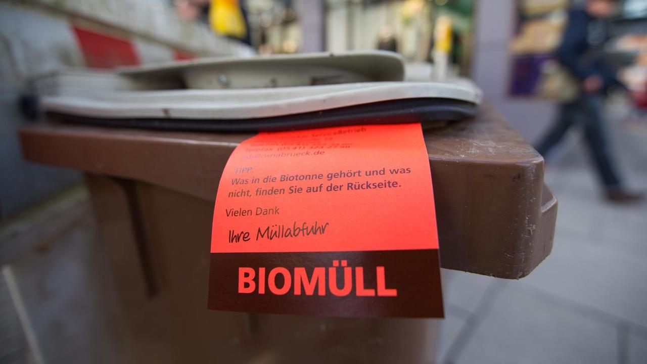 Ein Hinweiszettel mit dem Verzeichnis der richtigen Inhaltsstoffe für eine Biotonne der Müllabfuhr hängt am 24.02.2016 in Osnabrück (Niedersachsen) an einer Biotonne. 