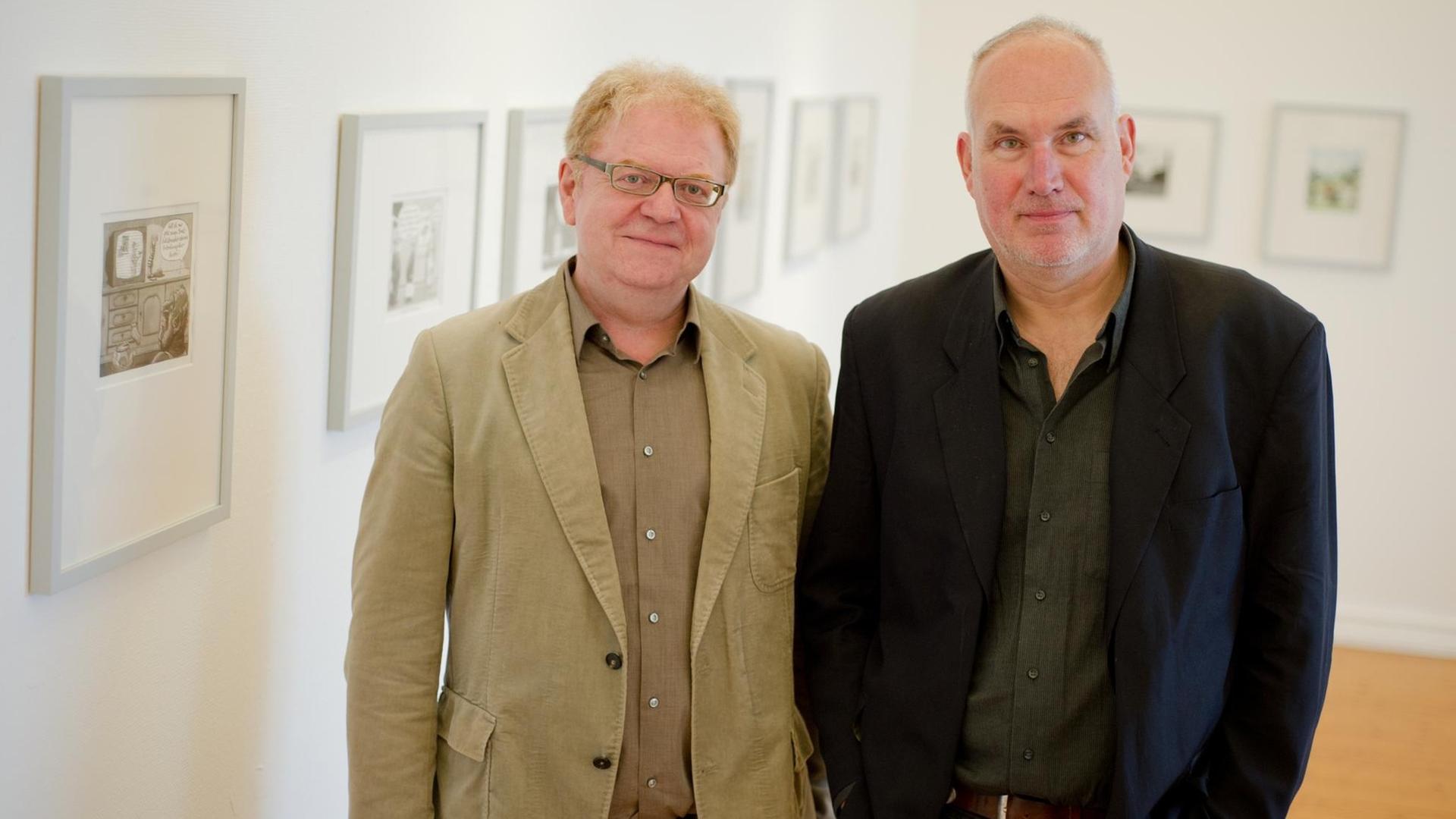 Die Karikaturisten Achim Greser und Heribert Lenz stehen vor ihren Bildern Die Karikaturisten Achim Greser und Heribert Lenz stehen vor ihren Bildern