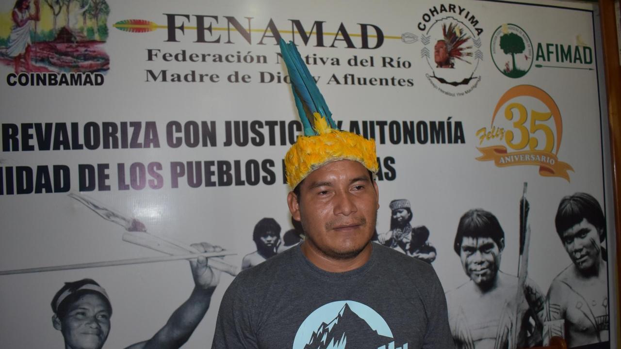 Eusebio Rios, der Vizepräsident des Indigenenverbands FENAMAD, der die sieben indigenen Völker der Amazonasregion Madre de Dios vertritt. Er trägt T-Shirt und eine traditionelle Kopfbedeckung Eusebio Rios, der Vizepräsident des Indigenenverbands FENAMAD, der die sieben indigenen Völker der Amazonasregion Madre de Dios vertritt. Er trägt T-Shirt und eine traditionelle Kopfbedeckung