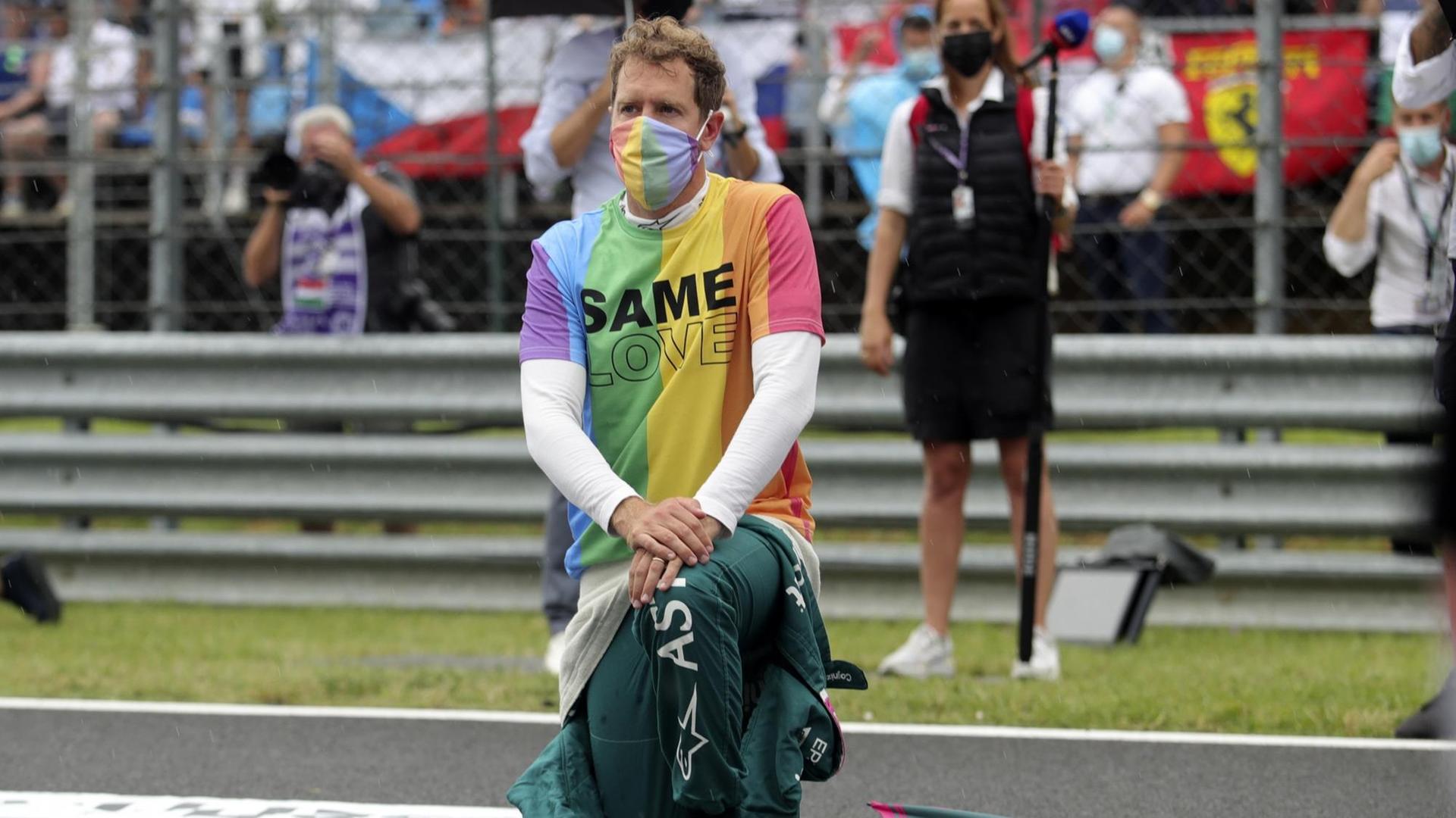 Ungarn, Mogyorod: Motorsport: Formel-1-Weltmeisterschaft, Großer Preis von Ungarn, Rennen: Sebastian Vettel aus Deutschland vom Team Aston-Martin kniet vor dem Rennen auf der Rennstrecke zur Unterstützung der Black-Lives-Matter-Bewegung nieder und trägt eine T-Shirt in Regenbogenfarben. Ungarn, Mogyorod: Motorsport: Formel-1-Weltmeisterschaft, Großer Preis von Ungarn, Rennen: Sebastian Vettel aus Deutschland vom Team Aston-Martin kniet vor dem Rennen auf der Rennstrecke zur Unterstützung der Black-Lives-Matter-Bewegung nieder und trägt eine T-Shirt in Regenbogenfarben.