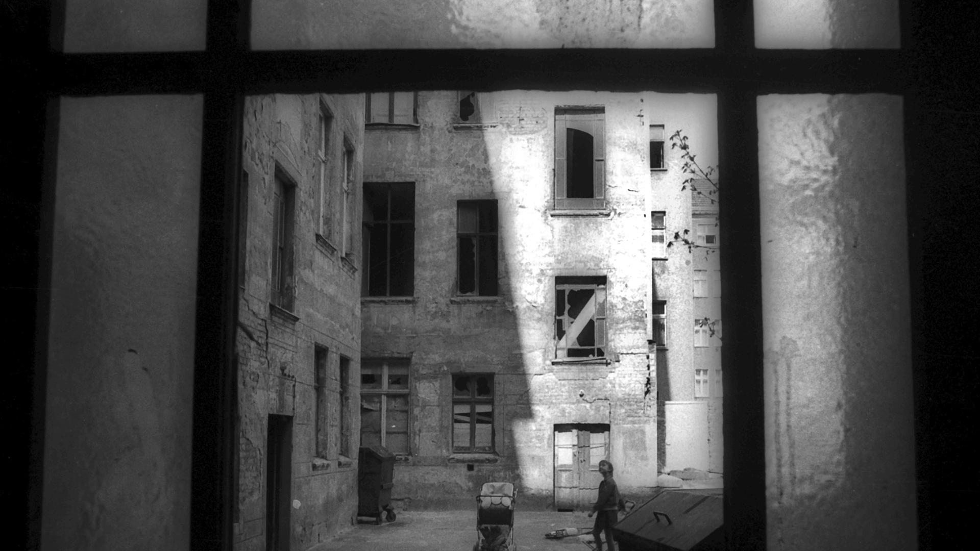 Ein Kinderwagen und ein Kind stehen in einem Hinterhof im Ost-Berliner Stadtbezirk Prenzlauer Berg, aufgenommen im Jahr 1981. Ein Kinderwagen und ein Kind stehen in einem Hinterhof im Ost-Berliner Stadtbezirk Prenzlauer Berg, aufgenommen im Jahr 1981.