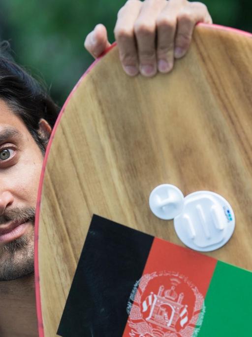 Der Exil-Afghane Afridun Amu posiert mit einem seiner Surfboards.