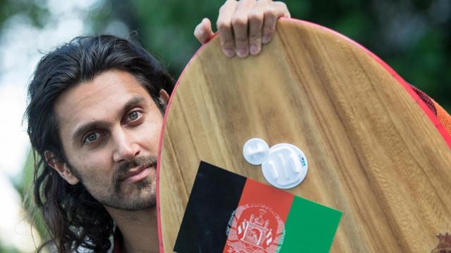 Der Exil-Afghane Afridun Amu posiert mit einem seiner Surfboards.