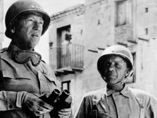 Der amerikanische General George S. Patton (l) und Brigadegeneral Theodor Roosevelt jr. (r) nach der Landung der alliierten Truppen im Juli 1943 in Gela auf Sizilien. Patton zeichnete sich im Zweiten Weltkrieg als Befehlshaber mehrerer US-Armeen militärisch aus. Er wurde 1896 in San Gabriel geboren und ist am 21. Dezember 1945 an den Folgen eines Autounfalls bei Mannheim gestorben. |