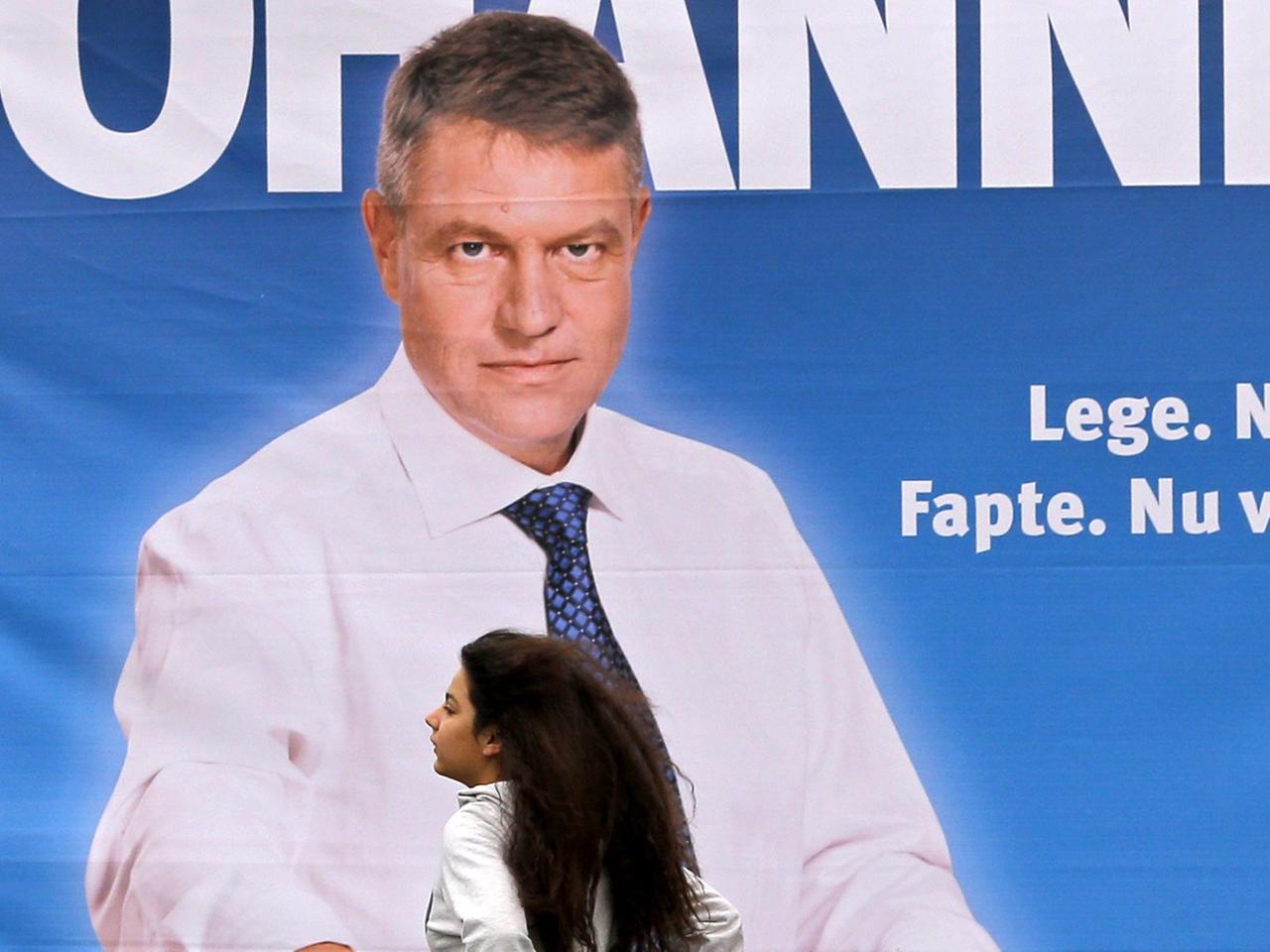 Eine Frau geht an einem Wahlplakat eines Kandidaten für die rumänische Präsientschaftswahl, Klaus Johannis, vorbei. Eine Frau geht an einem Wahlplakat eines Kandidaten für die rumänische Präsientschaftswahl, Klaus Johannis, vorbei.