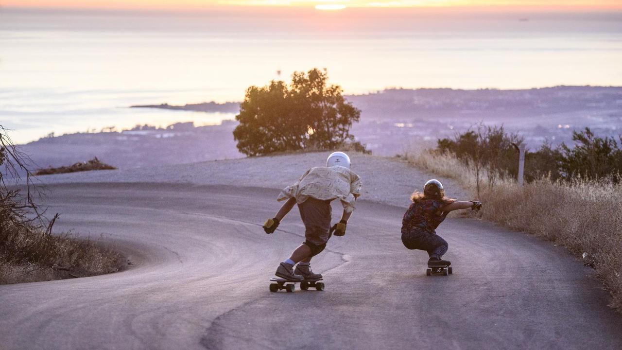 Zwei Skater fahren in Kalifornien eine Straße hinunter. Zwei Skater fahren in Kalifornien eine Straße hinunter.