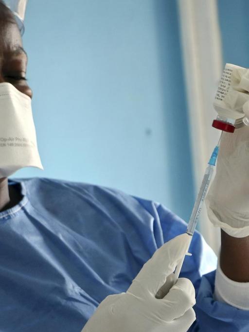 Medizinisches Personal beim Aufziehen einer Spritze für eine Impfung gegen Ebola im Kongo