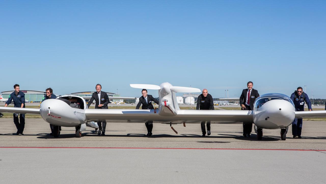 Gemeinsam schieben: Die HY4 nach dem Erstflug. Ab dritter Person von links: Georg Fundel, Geschäftsführer Flughafen Stuttgart, André Thess, Leiter DLR-Institut für Technische Thermodynamik, Ivo Boscarol, Geschäftsführer Pipistrel, Josef Kallo, Projektleiter HY4 im DLR, zusammen mit DLR-Mitarbeitern. Gemeinsam schieben: Die HY4 nach dem Erstflug. Ab dritter Person von links: Georg Fundel, Geschäftsführer Flughafen Stuttgart, André Thess, Leiter DLR-Institut für Technische Thermodynamik, Ivo Boscarol, Geschäftsführer Pipistrel, Josef Kallo, Projektleiter HY4 im DLR, zusammen mit DLR-Mitarbeitern.