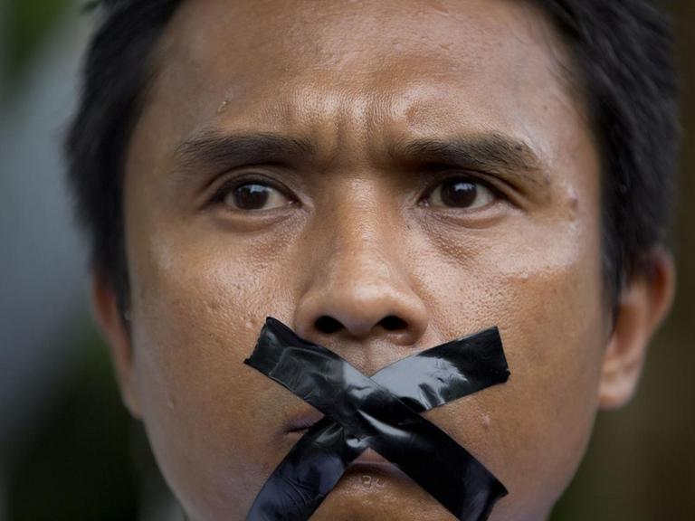 Ein Journalist aus Myanmar hat sich aus Protest gegen Zensur den Mund mit Klebeband verklebt.