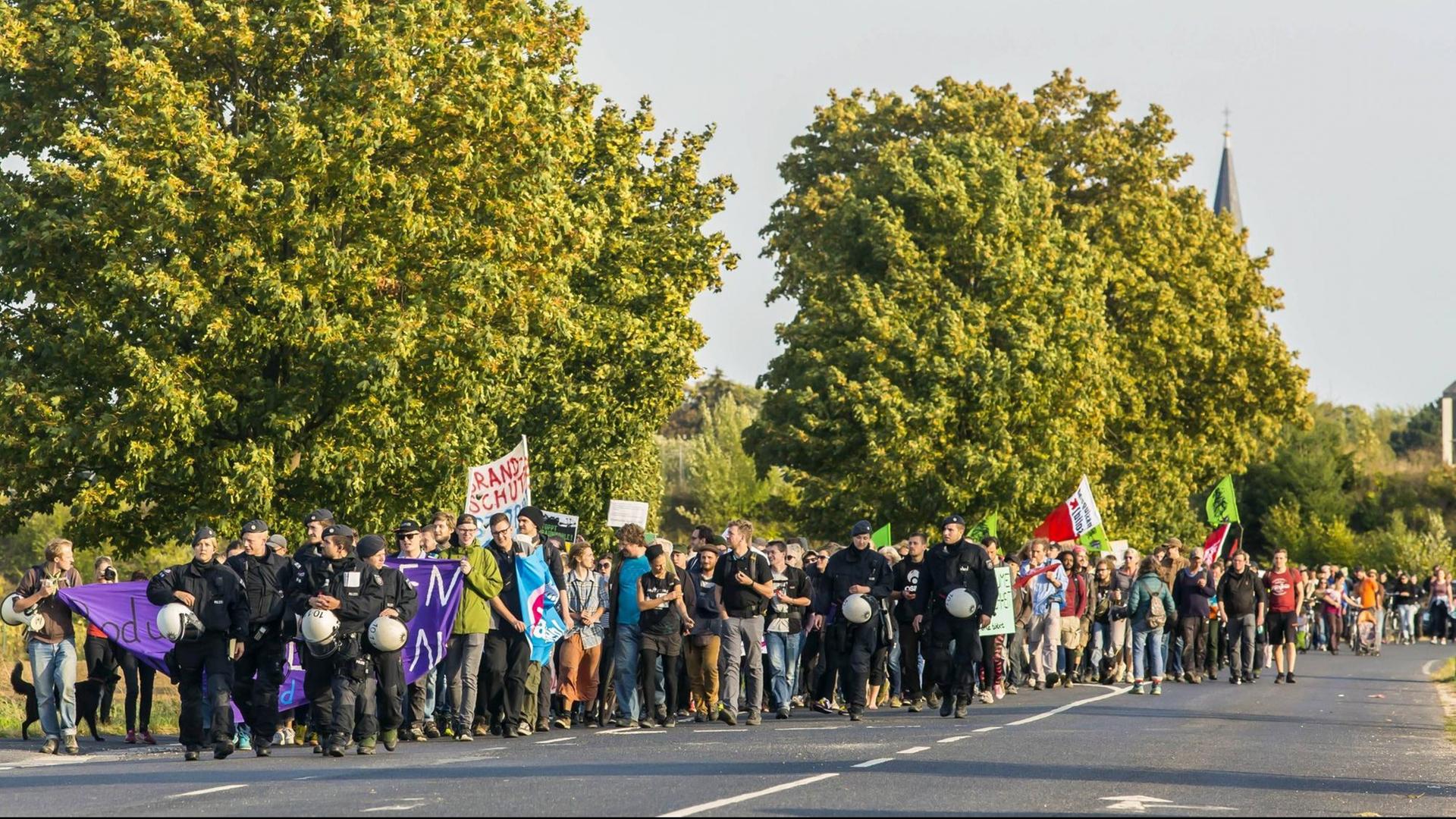 Ein Protestzug unterwegs in Richtung Hambacher Forst. Er wird von Polizisten begleitet. Ein Protestzug unterwegs in Richtung Hambacher Forst. Er wird von Polizisten begleitet.