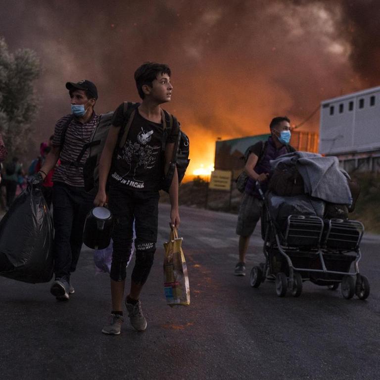 Migranten fliehen vor neu ausgebrochenen Feuern mit ihren Habseligkeiten aus dem Flüchtlingslager Moria.