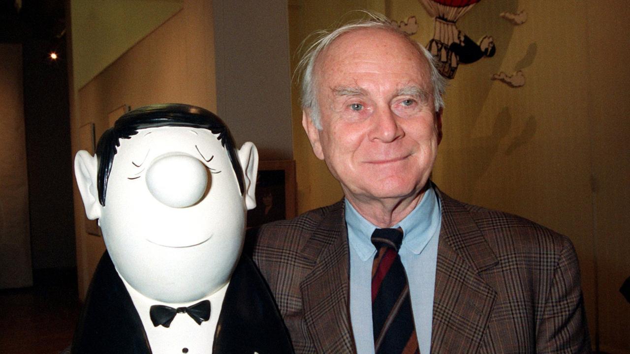 Vicco von Bülow hält die Büste der Hauptfigur seiner Karikaturen, einem korrekt gekleideten Strichmännchen mit Knollennase, im Arm. Vicco von Bülow hält die Büste der Hauptfigur seiner Karikaturen, einem korrekt gekleideten Strichmännchen mit Knollennase, im Arm.