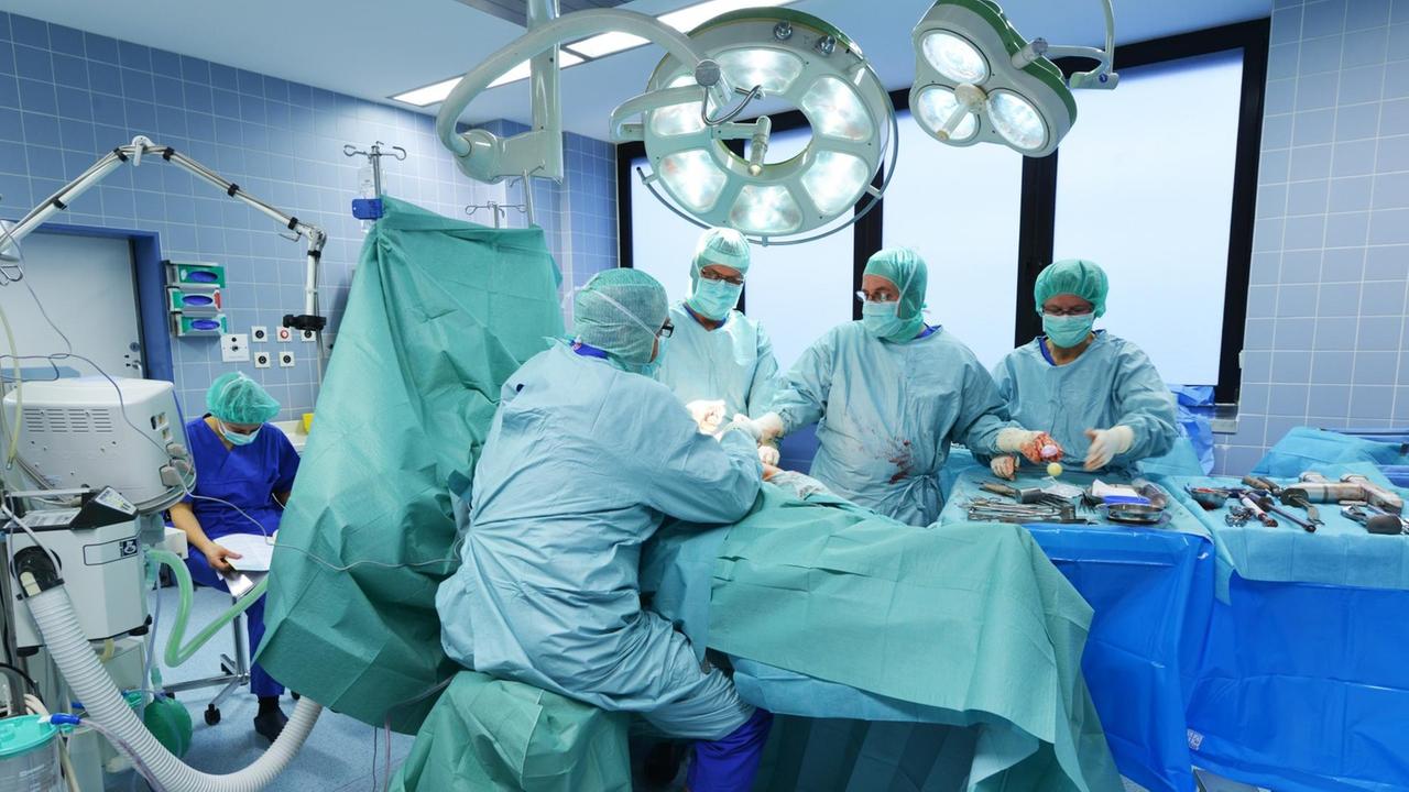 Ärzte setzen einem Patienten eine künstliche Hüfte ein. Ärzte setzen einem Patienten eine künstliche Hüfte ein.