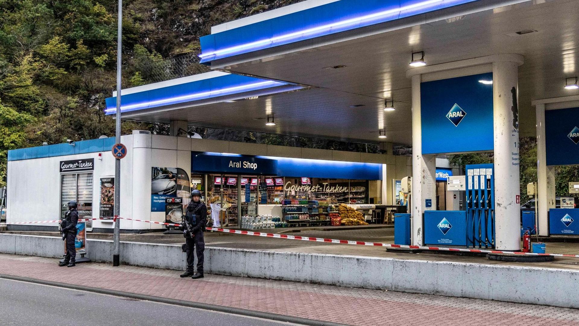 Polizisten stehen vor der Tankstelle, in der der Mann erschossen wurde. Polizisten stehen vor der Tankstelle, in der der Mann erschossen wurde.