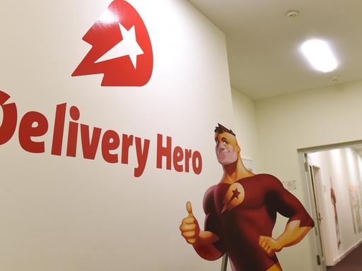 Das Logo von "Delivery Hero" und die Werbefigur von "Lieferheld" in der Firmenzentrale der Bestell-Plattformen in Berlin