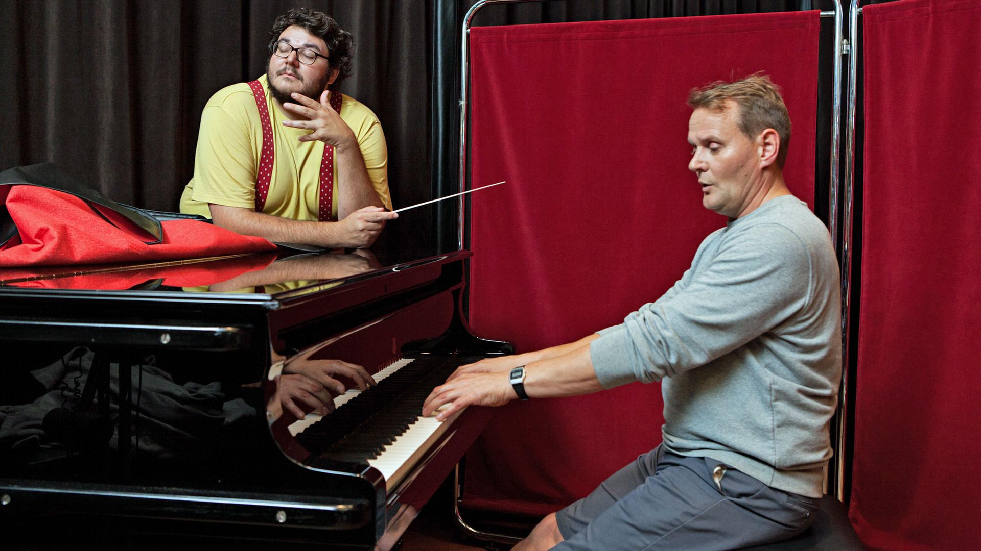 Axel Ranisch und Devid Striesow: Axel schwingt den Taktstock, während Devid Klavier spielt. Axel Ranisch und Devid Striesow: Axel schwingt den Taktstock, während Devid Klavier spielt.