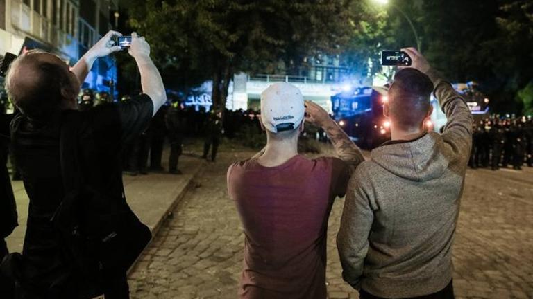 Drei Passanten filmen am 07.07.2017 im Schanzenviertel in Hamburg einen laufenden Polizeieinsatz Drei Passanten filmen am 07.07.2017 im Schanzenviertel in Hamburg einen laufenden Polizeieinsatz