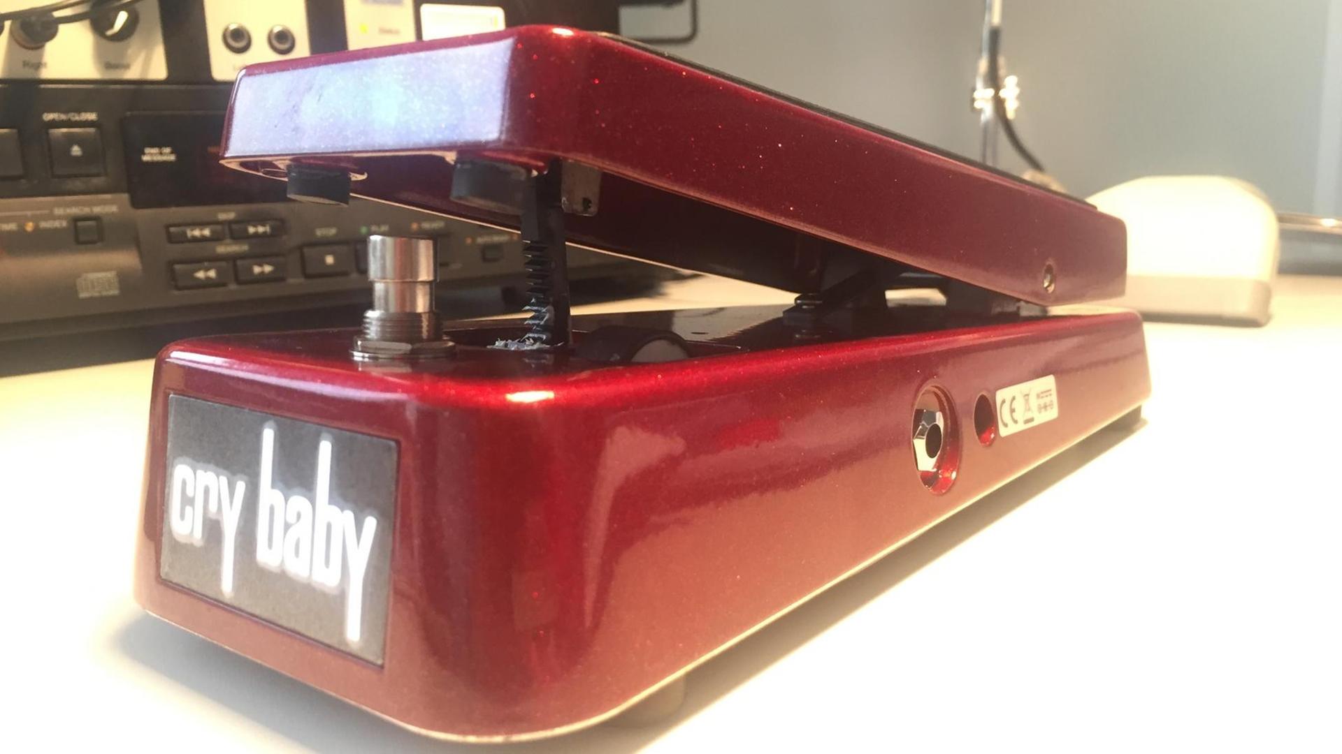 Ein rotes Effektpedal steht auf dem Boden: ein Wah Wah. Ein rotes Effektpedal steht auf dem Boden: ein Wah Wah.