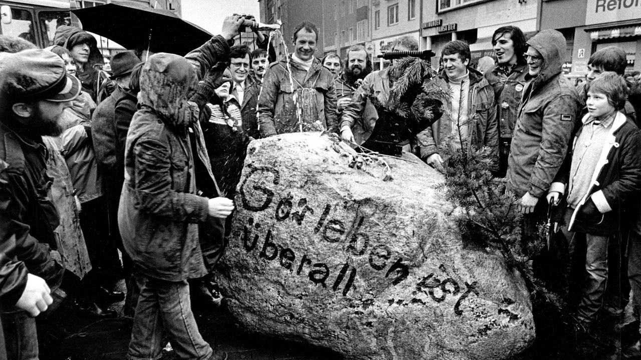 Demonstranten beim "Gorleben-Treck 1979" stehen um einen Stein mit dem Slogan "Gorleben ist überall". Die Demonstration gegen geplante Kernenergieanlagen bei Gorleben begann am 25. März 1979 im Wendland und endete als Abschlusskundgebung am 31. März 1979 in Hannover mit etwa 100.000 Teilnehmern. 
