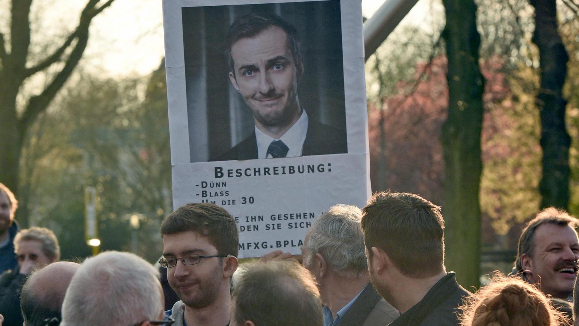 Ein Zuschauer hält in Marl (Nordrhein-Westfalen) vor der Verleihung der Grimmepreise eine Plakat mit der Aufschrift "Vermisst", das auf die Abwesenheit des Satirikers Jan Böhmermann hin weist. Ein Zuschauer hält in Marl (Nordrhein-Westfalen) vor der Verleihung der Grimmepreise eine Plakat mit der Aufschrift "Vermisst", das auf die Abwesenheit des Satirikers Jan Böhmermann hin weist.