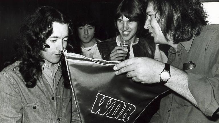 Die erste Rockpalast-Nacht: Rory Gallagher mit Alan Bangs (m.) und Peter Rüchel (r). in der Essener Grugahalle. Die erste Rockpalast-Nacht: Rory Gallagher mit Alan Bangs (m.) und Peter Rüchel (r). in der Essener Grugahalle.