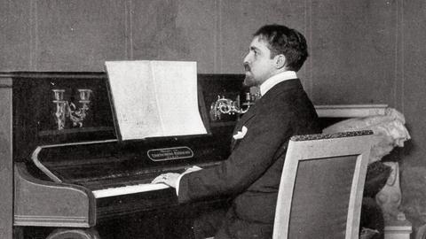 Reynaldo Hahn auf einer historischen Fotografie am Klavier sitzend und spielend.