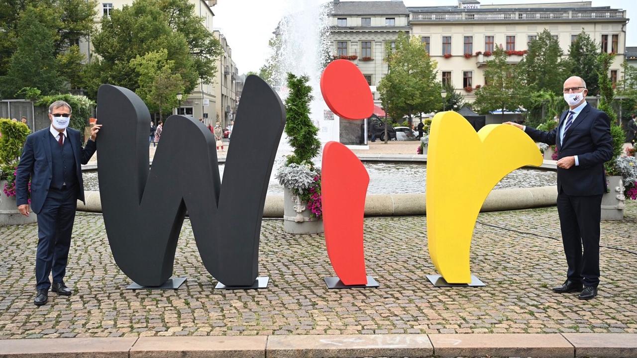 Brandenburg, Potsdam: Dietmar Woidke (r, SPD), Bundesratspräsident und Ministerpräsident von Brandenburg, und Burkhard Exner (SPD), Bürgermeister von Potsdam, enthüllen auf dem Luisenplatz den Schriftzug "WIR". Brandenburg, Potsdam: Dietmar Woidke (r, SPD), Bundesratspräsident und Ministerpräsident von Brandenburg, und Burkhard Exner (SPD), Bürgermeister von Potsdam, enthüllen auf dem Luisenplatz den Schriftzug "WIR".