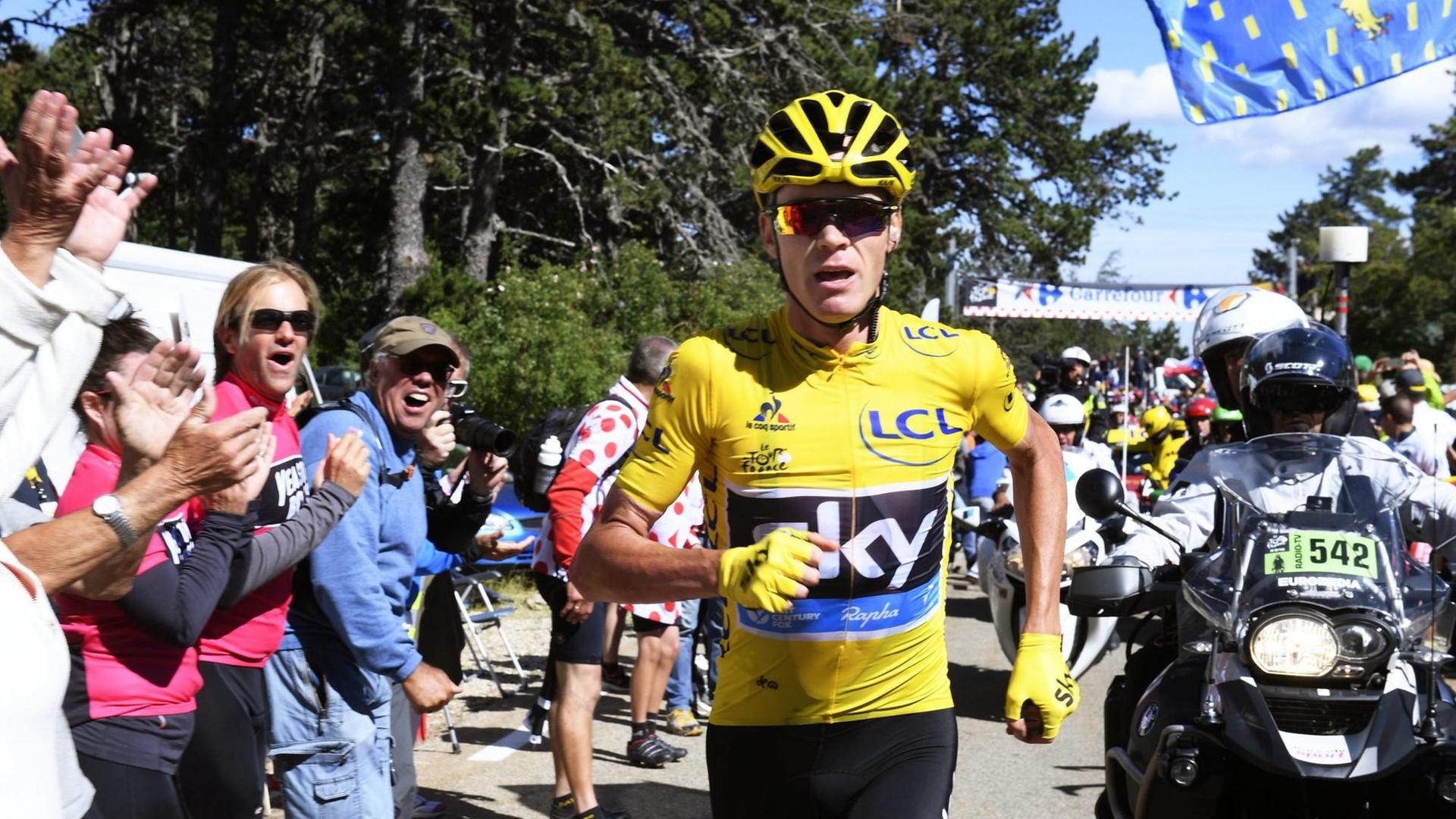 Der britsche Rennfahrer Christopher Froome des Team Sky beendet eine Etappe der Tour de France nach einem Sturz laufend. Der britsche Rennfahrer Christopher Froome des Team Sky beendet eine Etappe der Tour de France nach einem Sturz laufend.