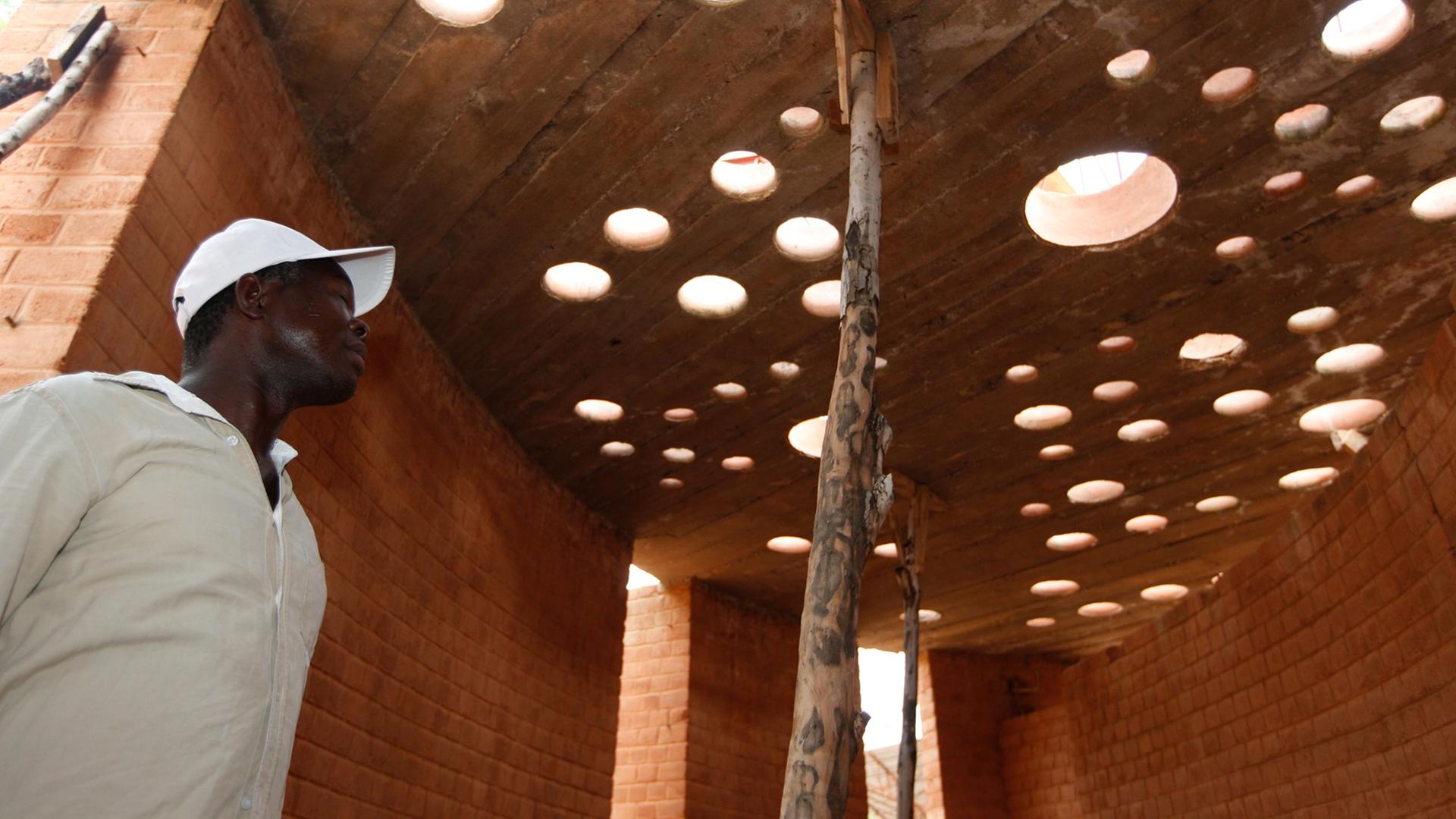 Der Architekt Francis Kéré begutachtet in dem burkinischen Dorf Gando den Baufortschritt an einem Bibliotheksgebäude. Der Architekt Francis Kéré begutachtet in dem burkinischen Dorf Gando den Baufortschritt an einem Bibliotheksgebäude.