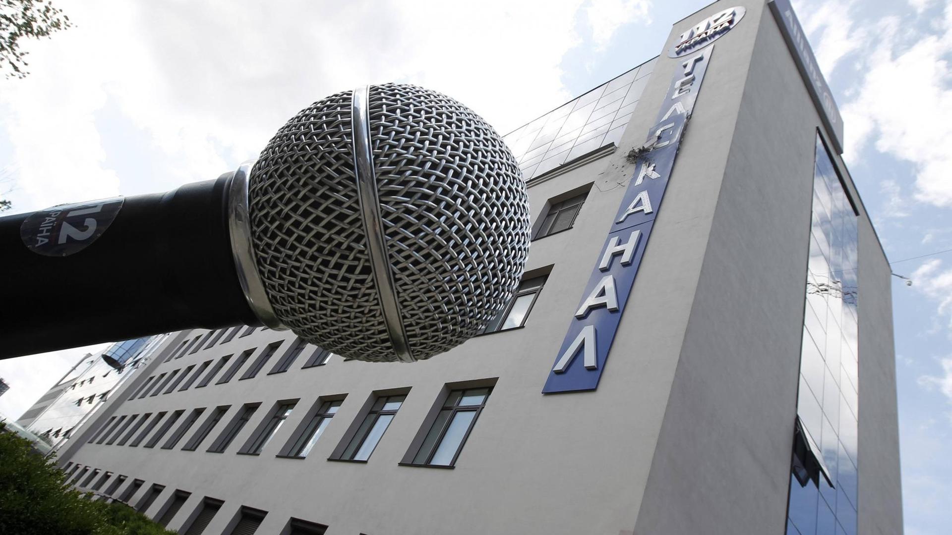Vor dem Gebäude des ukrainischen Fernsehsenders "112" in Kiew steht ein überdimensionales Mikrofon. Der Schriftzug an der Fassade ist durch einen Angriff zerstört. Vor dem Gebäude des ukrainischen Fernsehsenders "112" in Kiew steht ein überdimensionales Mikrofon. Der Schriftzug an der Fassade ist durch einen Angriff zerstört.