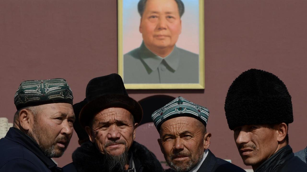 Eine Delegation traditionell gekleideter Uiguren aus der Provinz Xinjiang posiert vor Beginn des chinesischen Volkskongress 2013 unter dem Mao-Bildnis über dem Tor des Himmlischen Friedens in Peking. Eine Delegation traditionell gekleideter Uiguren aus der Provinz Xinjiang posiert vor Beginn des chinesischen Volkskongress 2013 unter dem Mao-Bildnis über dem Tor des Himmlischen Friedens in Peking.