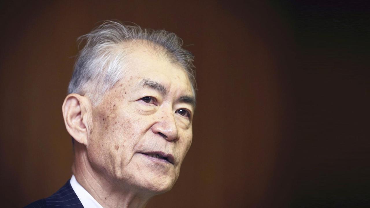Seitliches Porträt von Tasuku Honjo vor schwarz-braunem Hintergrund. Seitliches Porträt von Tasuku Honjo vor schwarz-braunem Hintergrund.