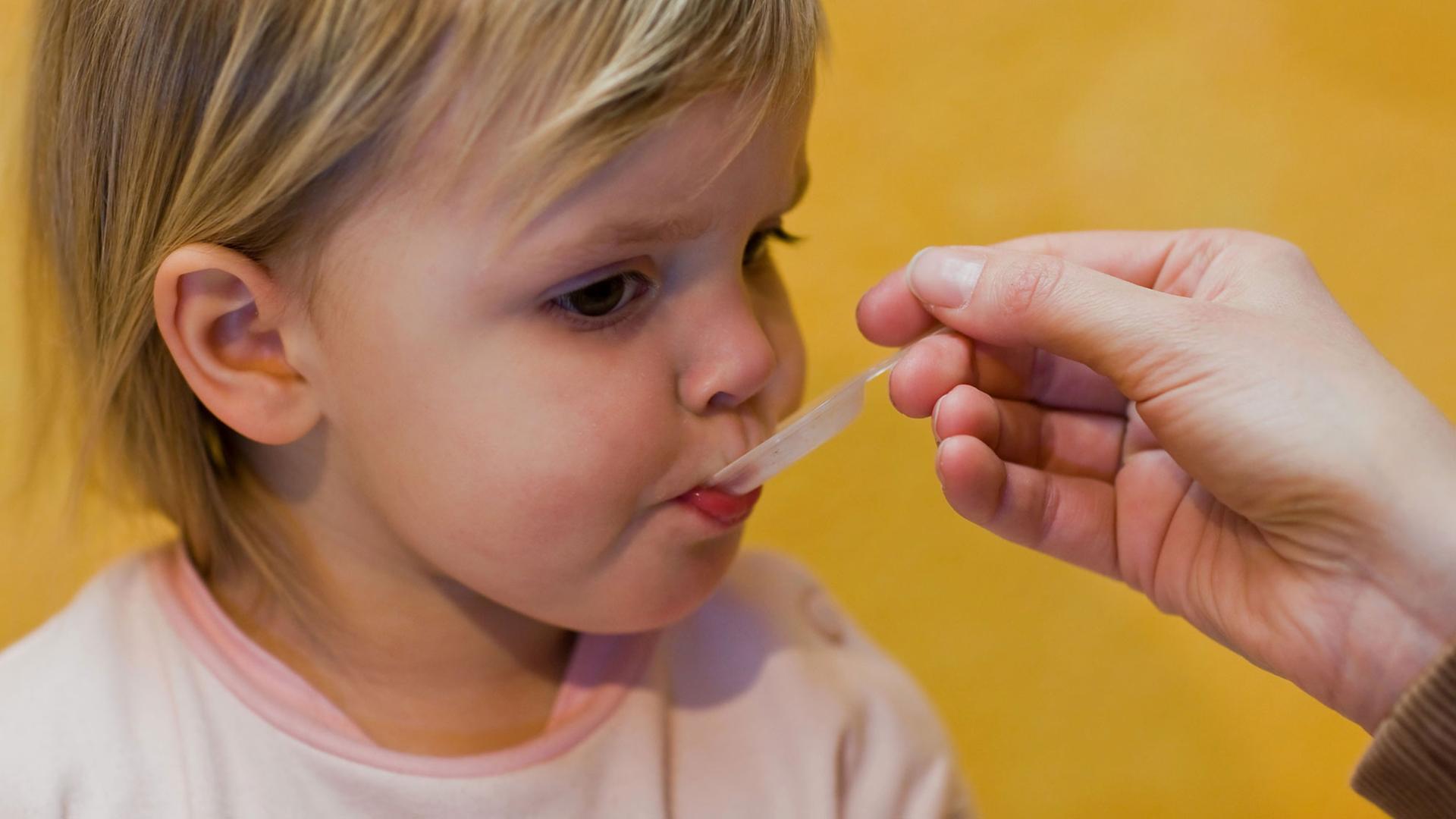 Eine Mutter gibt ihrem Kind ein homöopathisches Mittel. Eine Mutter gibt ihrem Kind ein homöopathisches Mittel.
