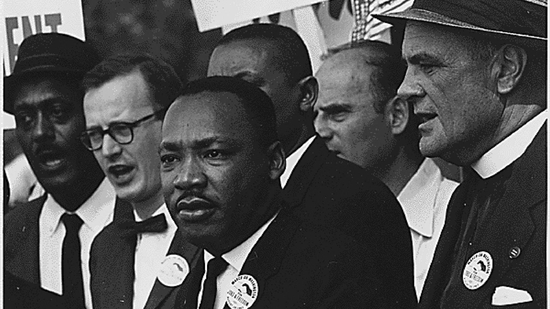 Martin Luther King inmitten einer Gruppe von Menschen anlässlich des Marsches auf Washington im August 1963. Martin Luther King inmitten einer Gruppe von Menschen anlässlich des Marsches auf Washington im August 1963.