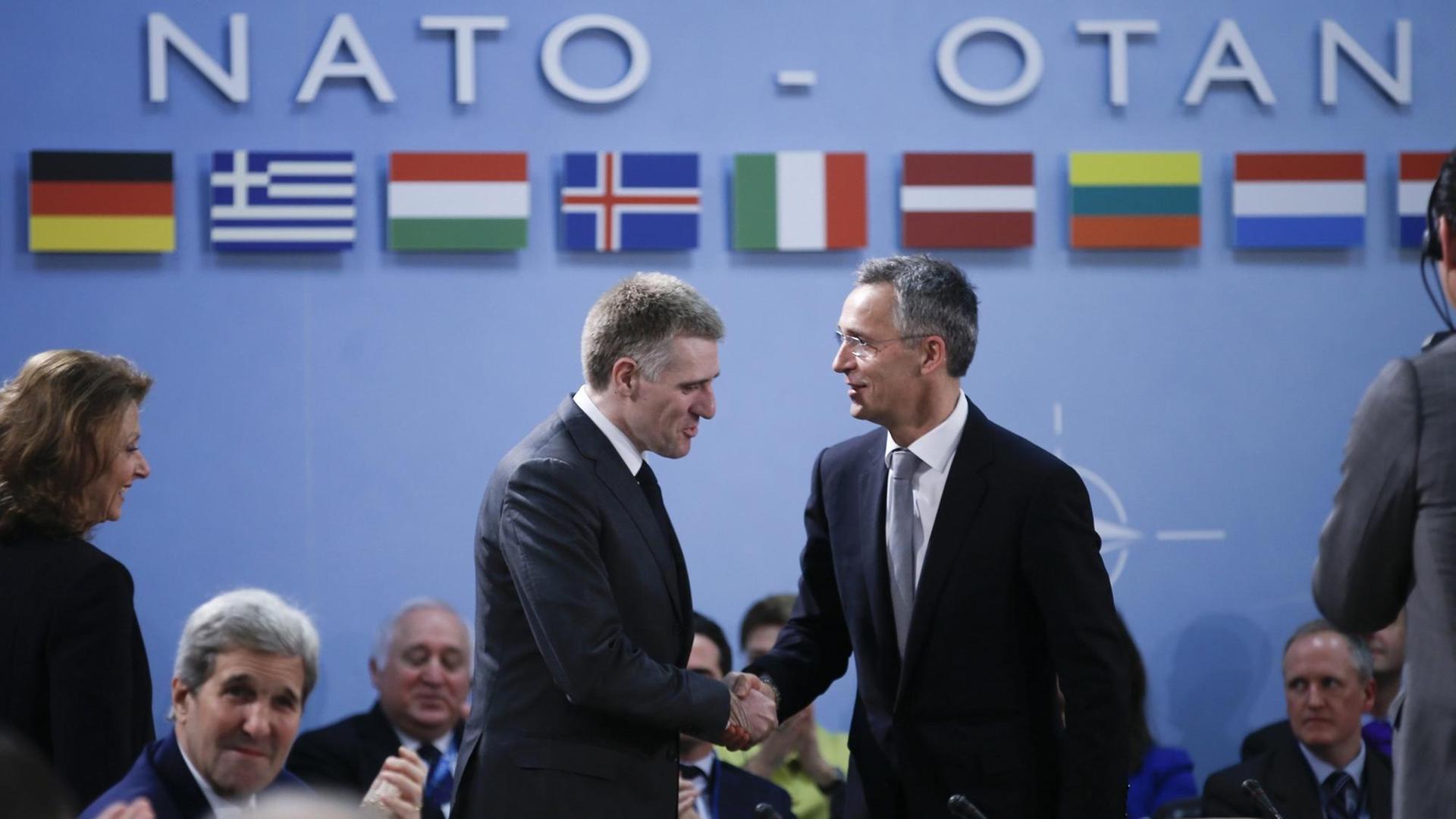 Der Außenminister Montenegros, Igor Luksic, schüttelt die Hände mit Nato-Generalsekretär Jens Stoltenberg beim Nato-Außenministertreffen in Brüssel.