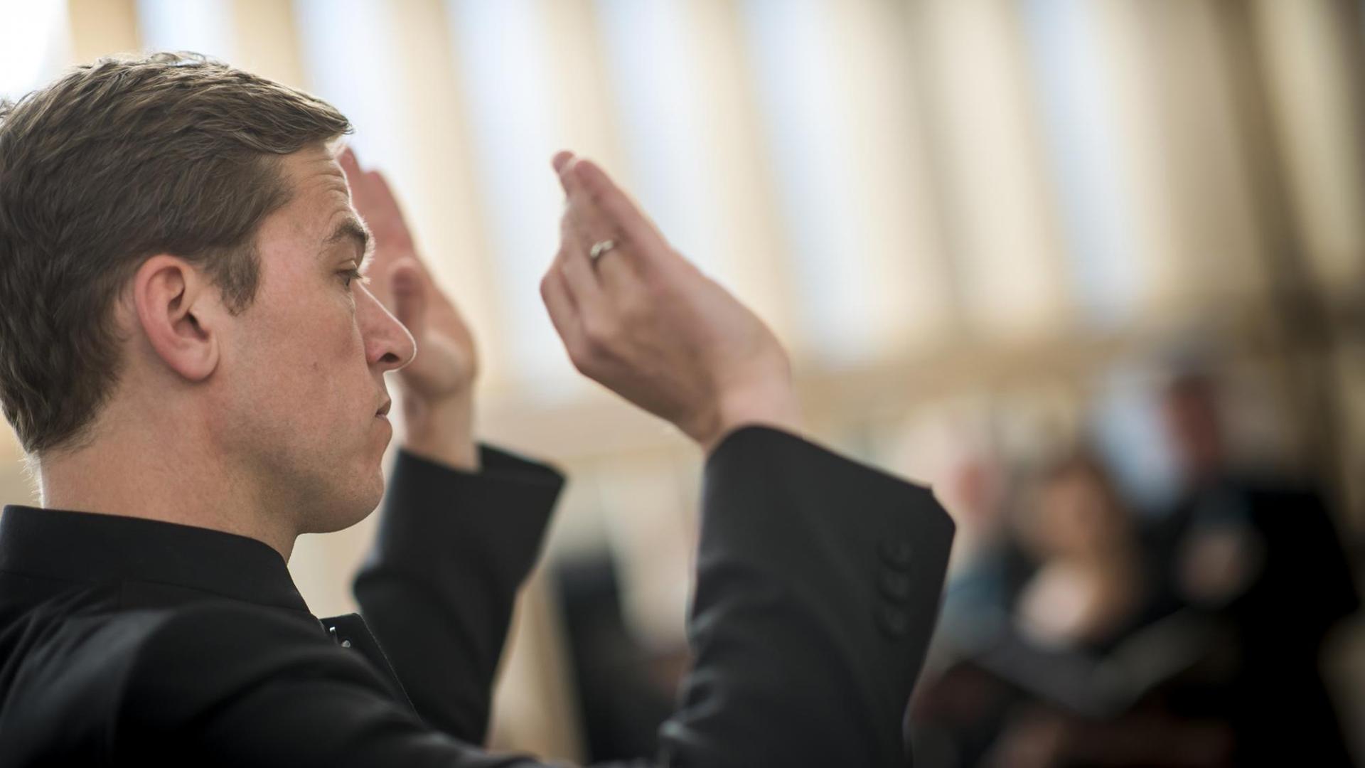 Der Chorleiter Florian Helgath dirigiert Der Chorleiter Florian Helgath dirigiert
