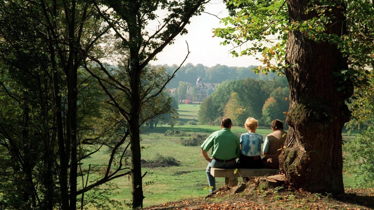 Auf der polnischen Seite des Pücklerparks in Leknica sitzen Spaziergänger auf der Steinbank am Mausoleumshügel und genießen den Blick entlang der längsten Sichtachse des Parks bis zum Schloss in Bad Muskau auf der sächsichen Seite. Auf der polnischen Seite des Pücklerparks in Leknica sitzen Spaziergänger auf der Steinbank am Mausoleumshügel und genießen den Blick entlang der längsten Sichtachse des Parks bis zum Schloss in Bad Muskau auf der sächsichen Seite.