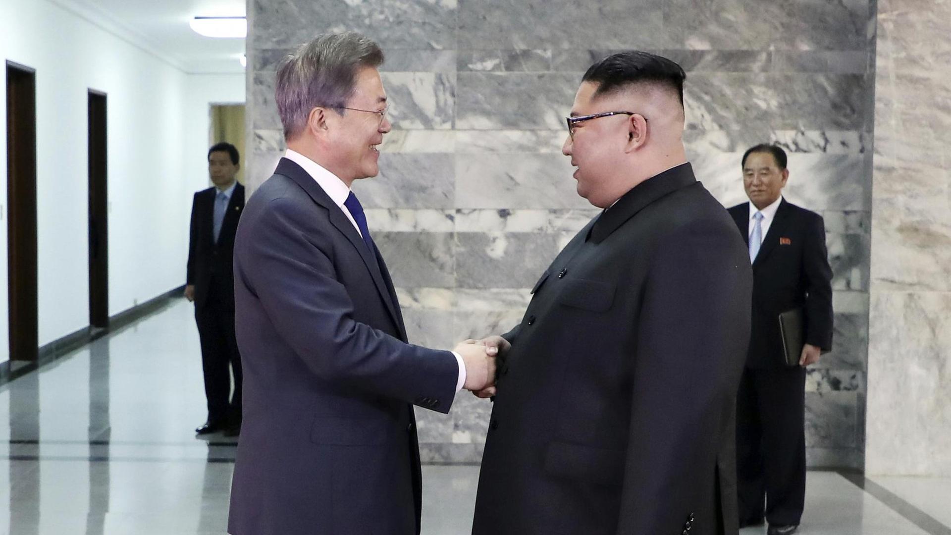Dieses vom Blauen Haus, dem südkoreanischen Präsidialamt zur Verfügung gestellte Foto zeigt Kim Jong Un (r), Machthaber in Nordkorea, und Moon Jae In, Präsident von Südkorea, die sich bei einem zweiten Treffen auf der nördlichen Seite der Grenze in der demilitarisierten Grenzstadt Panmunjom die Hand geben. Dieses vom Blauen Haus, dem südkoreanischen Präsidialamt zur Verfügung gestellte Foto zeigt Kim Jong Un (r), Machthaber in Nordkorea, und Moon Jae In, Präsident von Südkorea, die sich bei einem zweiten Treffen auf der nördlichen Seite der Grenze in der demilitarisierten Grenzstadt Panmunjom die Hand geben.