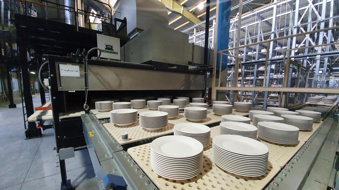 Aufeinandergestapelte Porzellanteller in großer Menge auf einer großen Maschine. Aufeinandergestapelte Porzellanteller in großer Menge auf einer großen Maschine.