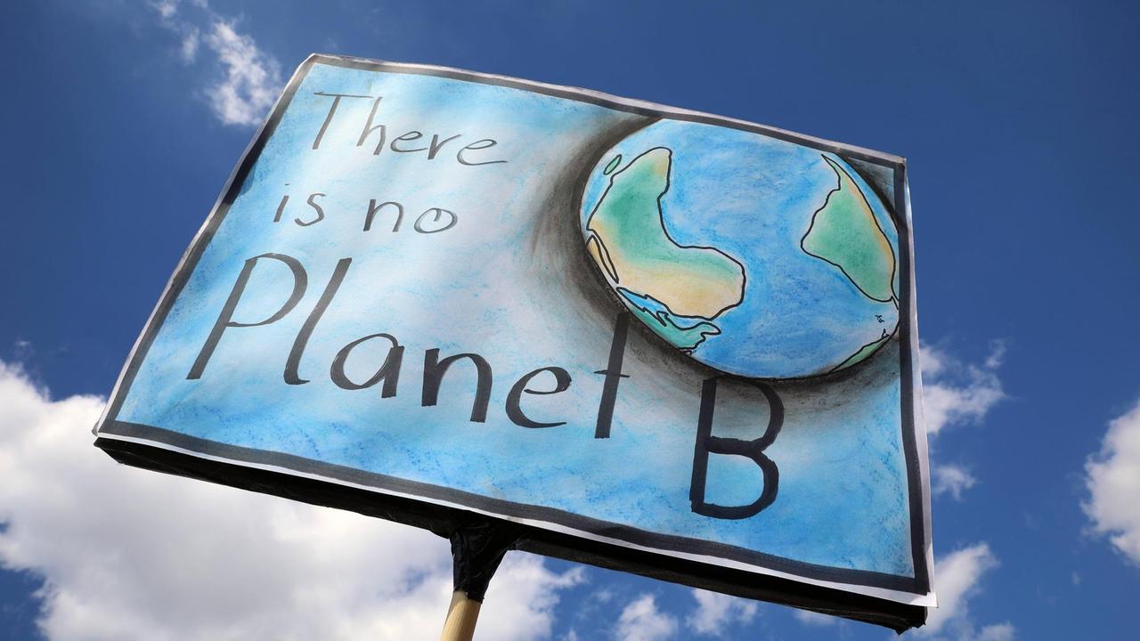 Ein Schild mit der Aufschrift "There is no Planet B" - im Hintergund der blaue Himmel Ein Schild mit der Aufschrift "There is no Planet B" - im Hintergund der blaue Himmel