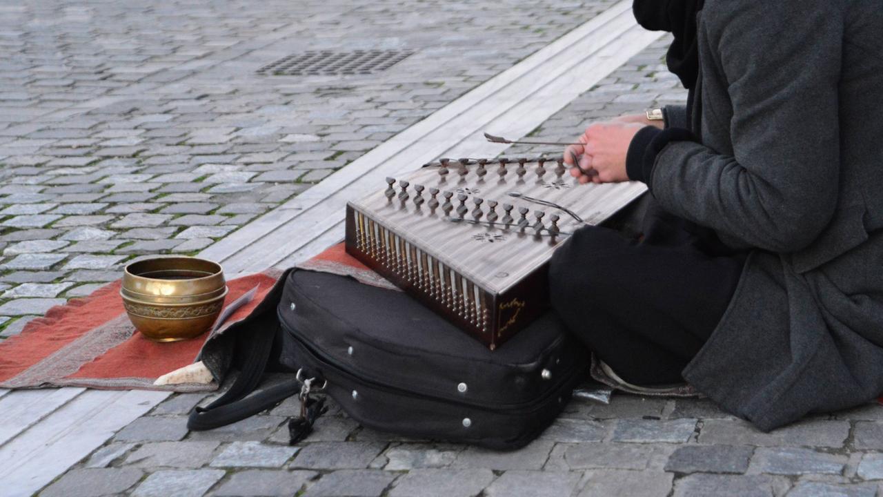 Ein junger Straßenmusikant in Athen spielt Santur, ein persisches Musikinstrument Ein junger Straßenmusikant in Athen spielt Santur, ein persisches Musikinstrument